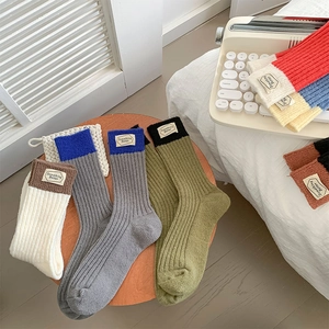 Détail de chaussettes en laine tricotée avec étiquette et design bicolore contrasté