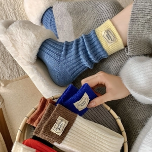 Gros plan détaillé de chaussettes en laine épaisse avec étiquette tissée 'Something Better'