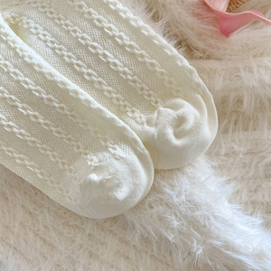 Detail of cream knit socks featuring delicate openwork patterns and soft cable textures