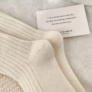 Gros plan sur la maille côtelée beige de chaussettes en laine avec détail de carte déco