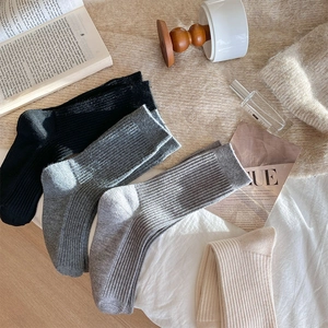 Detailed knit texture of four pairs of warm wool blend socks in autumn neutral colors