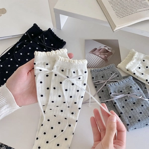 Détail de chaussettes à pois de style japonais avec dentelle et nœud en ruban