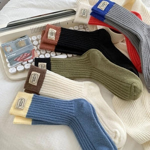 Gros plan de chaussettes en laine côtelée avec blocs de couleurs et étiquette tissée