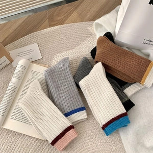 Détail de chaussettes en laine à rayures avec revers contrastés et mailles côtelées