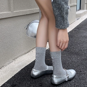Detail of grey knitted socks with satin bow accent and stylish vertical rib texture