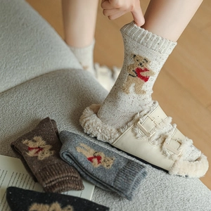 Detail of wool socks featuring cute bear embroidery and thick thermal knit texture