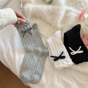 Detailed knit texture and sweet bow accents on grey white and black crew socks