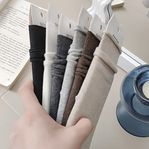 Close-up of six pairs of ribbed cotton mid-calf socks in earthy neutral tones on display