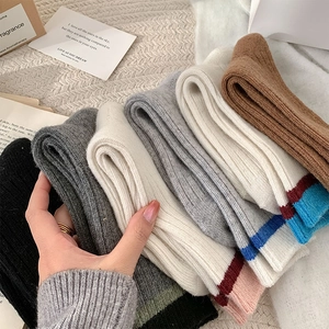 Détail de chaussettes en laine épaisses avec rayures contrastées et texture côtelée