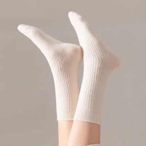 Macro detail of ribbed knit texture on warm cream white wool crew socks for women
