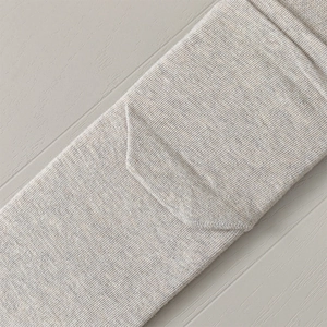 Detail of oatmeal ribbed knit socks showing fine texture and heel seam construction