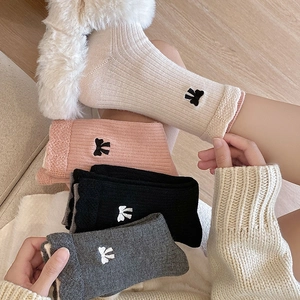 Détail de la texture de chaussettes en laine avec nœuds brodés mignons et bords côtelés