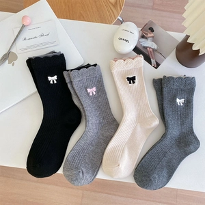 Détail de broderie nœud doux et revers ondulés sur chaussettes en laine tricotées en 4 couleurs