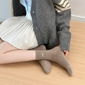 Close-up of brown crew socks featuring white Hi embroidery and heart detail