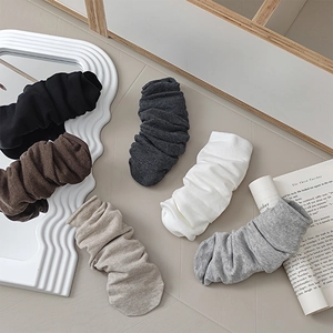 Detailed knit texture of solid color slouch socks in various neutral tones and ribbed finish