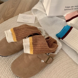 Détail de sabots d'hiver douillets avec doublure peluche et chaussettes en laine rayées