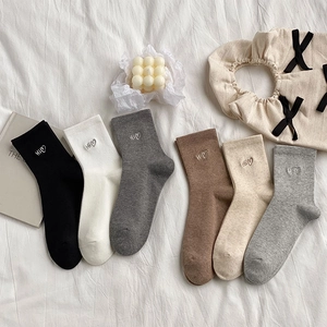 Detail view of cotton mid-calf socks in six neutral colors with Hi heart embroidery