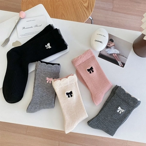 Gros plan de chaussettes en laine d'hiver avec nœud brodé et doublure polaire
