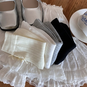 Detail of ballet style rib-knit cotton socks in beige with sweet ribbon bow decoration
