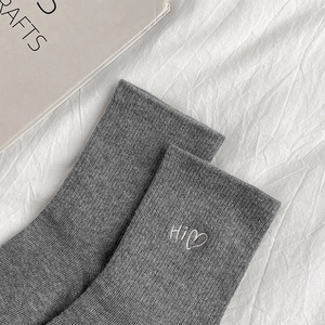 Close-up of grey knit sock featuring white Hi heart embroidery and ribbed texture