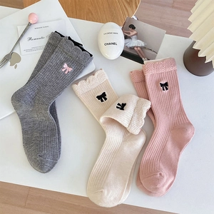 Détail de trois paires de chaussettes d'hiver en laine avec nœuds brodés et dentelle
