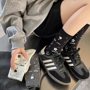 Detailed knit texture of mid-calf socks with star patterns and stylish smile typography