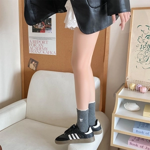 Détail de chaussettes en laine avec broderie nœud et bord en dentelle avec baskets rétro