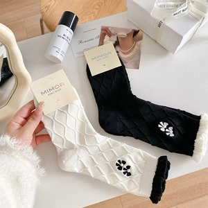 Detail of knit crew socks featuring 3D floral accents and elegant faux pearl embellishments