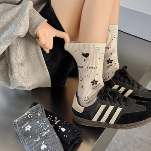 Detail of colorful knitted mid-calf socks with star and smiley graffiti patterns