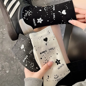 Detail of cotton ribbed mid-tube socks with graffiti smile and star patterns in three colors