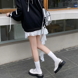 Outdoor side view of white platform loafers paired with ballet-style bow socks and dress