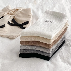 Detailed close-up of Hi heart embroidery on cotton socks in earthy autumn tones