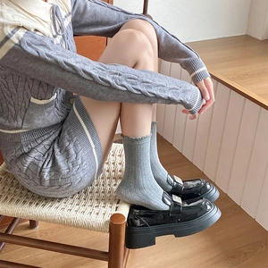 Détail de chaussettes en coton gris à rayures avec des mocassins en cuir à plateforme