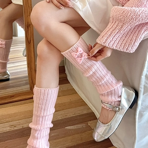 Détails de jambières roses en tricot avec des nœuds et des motifs à rayures verticales
