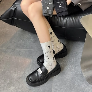 Detail of trendy mid-tube socks featuring graffiti smiley faces and star patterns