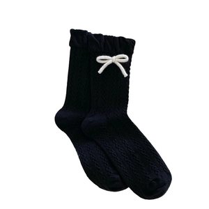 Sweet black knit crew socks with white bows and cable texture on white background