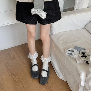 Detailed view of white cotton lace trim socks with embroidery paired with Mary Jane shoes