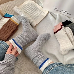 Gros plan de chaussettes en laine tricotée épaisse avec bords côtelés contrastés d'automne