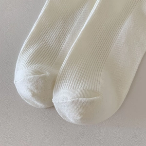 Detailed macro view showing the smooth toe seams and ribbed texture of white lace socks