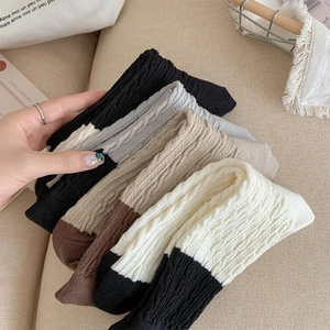 Detailed close-up of ribbed knit socks in assorted neutral tones and cotton texture