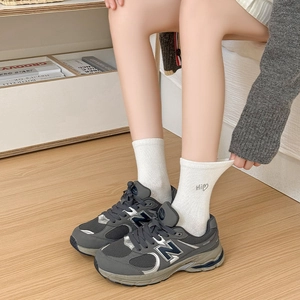 Close-up of white ribbed crew socks featuring a cute embroidered Hi heart design on the cuff