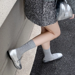 Silver glossy Mary Jane shoes with buckles and bow socks in a ballet style outfit