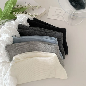 Flat lay of ribbed knit mid-calf socks with white lace trim in five neutral colors