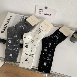Detailed view of three crew socks in grey, beige, and black with street graffiti patterns