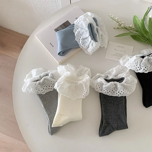 Flat lay of ribbed cotton mid-calf socks with delicate white lace trim in five colors