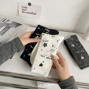 Detail of ribbed cotton mid-calf socks with star, heart and smile face graffiti patterns