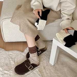 Close-up of color-block knit mid-calf socks with vintage vertical texture and elastic cuffs