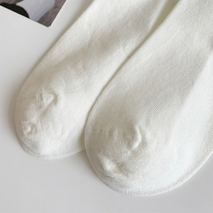 Close-up of white ribbed socks showing high-quality vertical texture and soft knit fabric