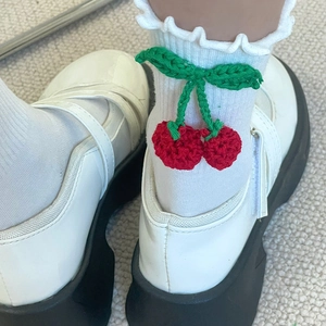 Détail de chaussettes à volants avec cerises crochetées et chaussures Mary Jane