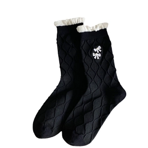 Japanese style black crew socks featuring white ruffle trim and embroidered bow accents
